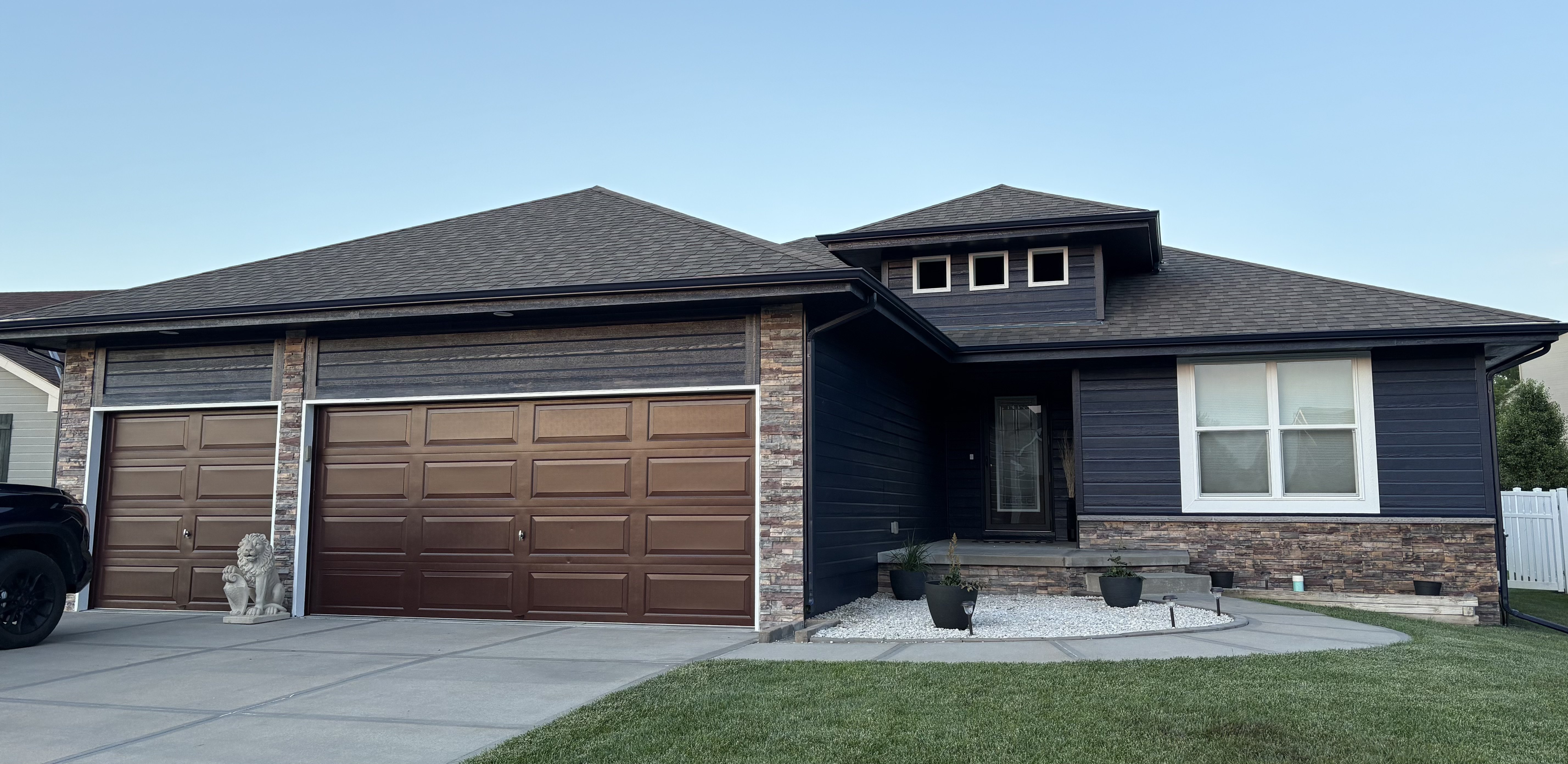 Dark, dramatic exterior color change on a stone-accented home